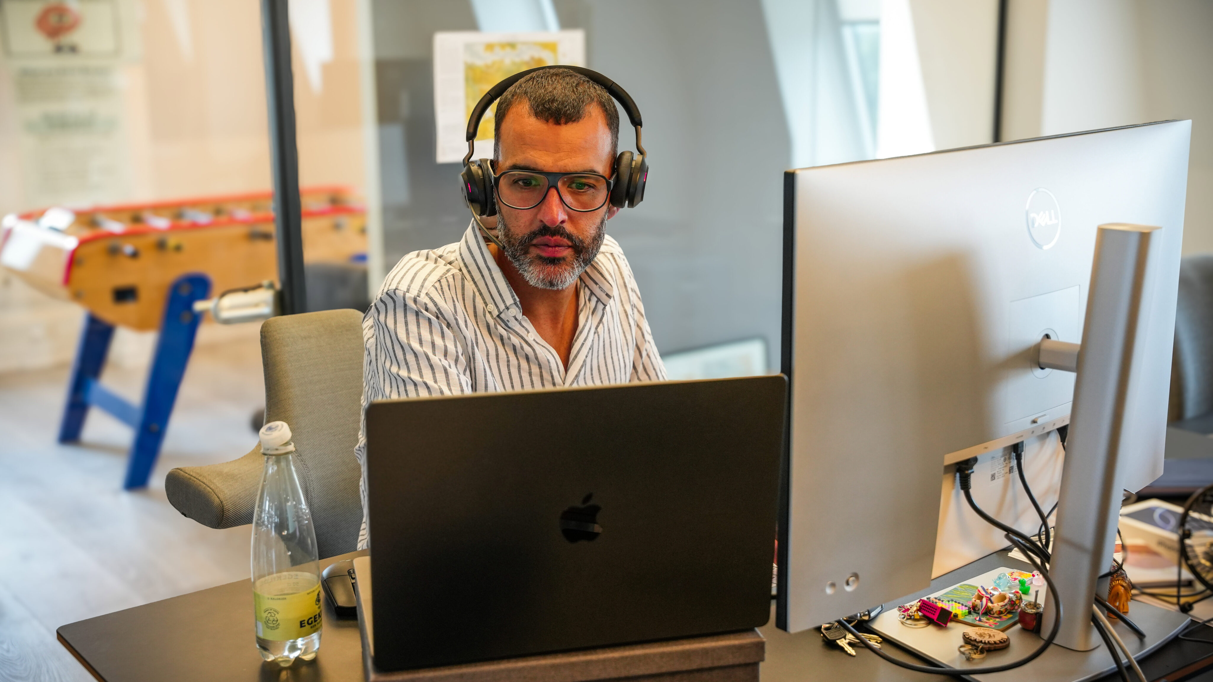 Innovative workspace with a professional man working on a laptop, emphasizing remote work and tech careers at Keylane.