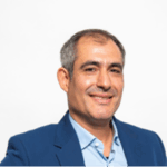 Innovative tech professional smiling in a blue suit, representing Keylane Careers’ dynamic workplace and career opportunities in insurance technology and software development.