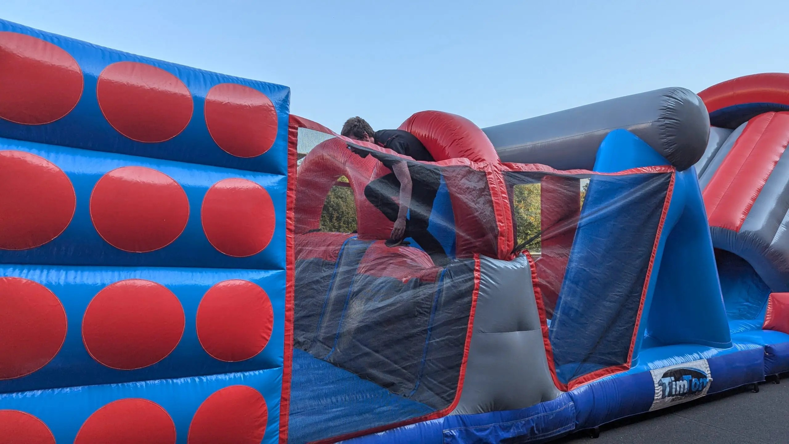 Inflatable obstacle course designed for outdoor team-building activities and fun, featuring colorful slides, crawling tunnels, and climbing sections for all ages.